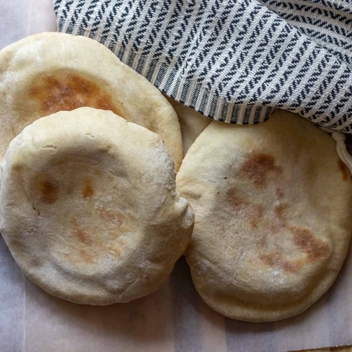 3 pieces of flatbread covered with a clean cloth.